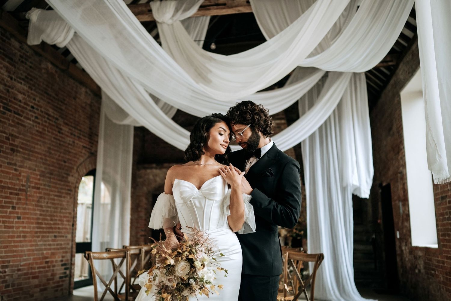 Bride and groom portrait beneath draped wedding decor in Lincolnshire