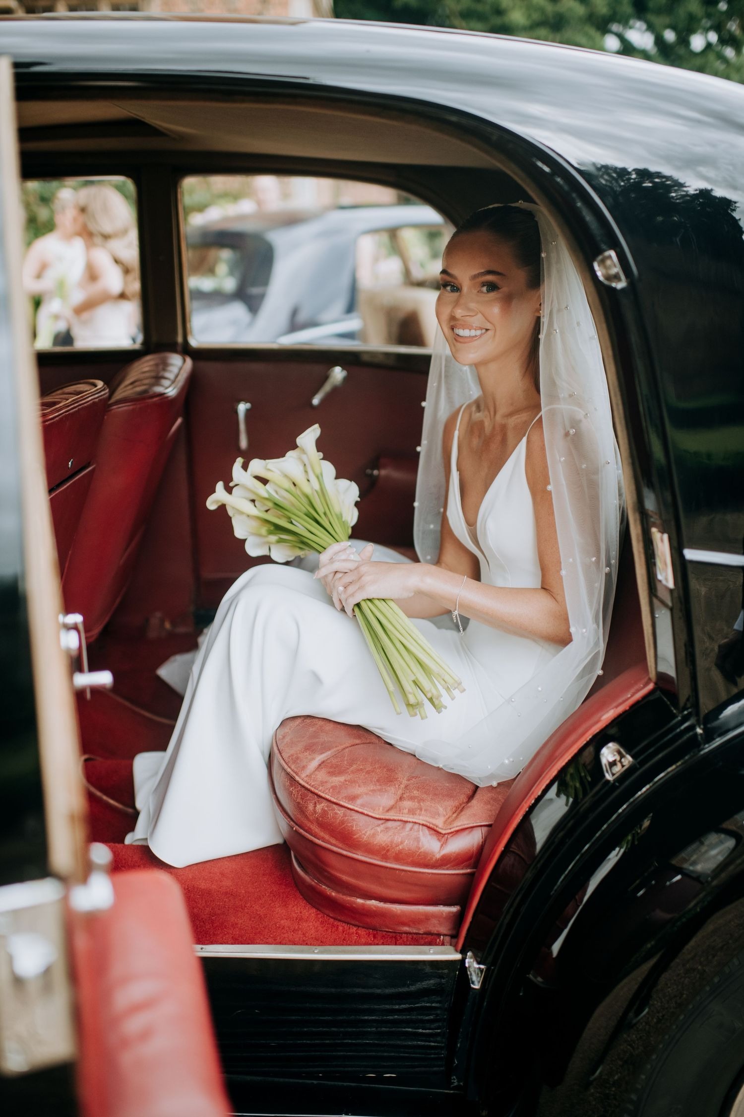 Bride arriving at wedding venue in vintage car in Lincolnshire