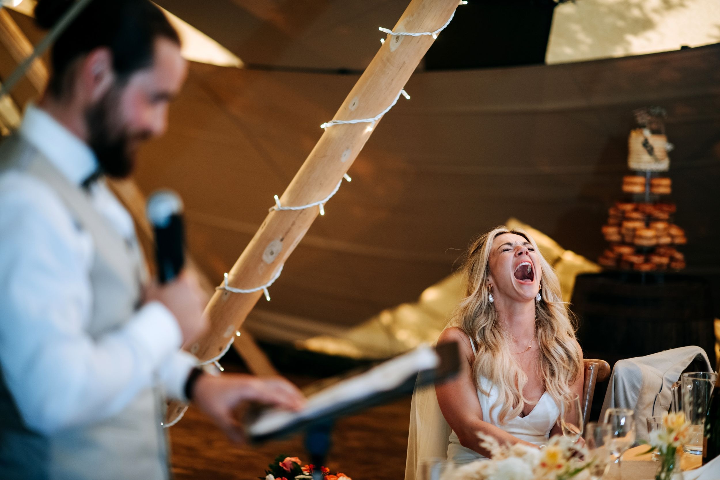 Bride laughing during wedding speeches at Scrivelsby wedding venue
