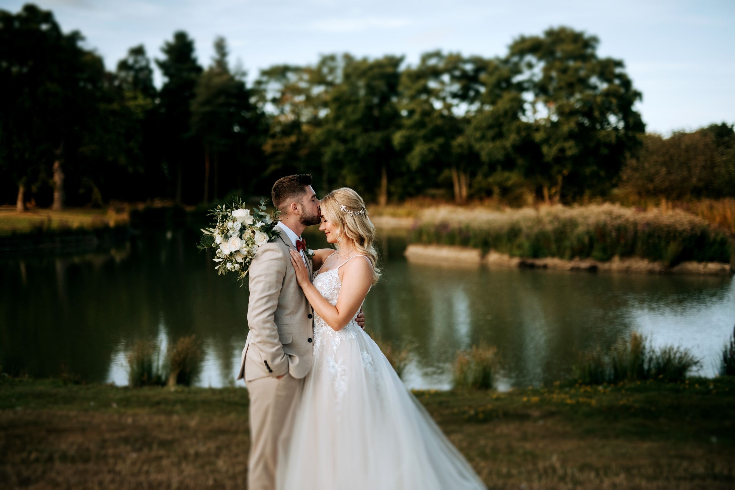 Bride and groom portrait beside lake at Stubton Hall