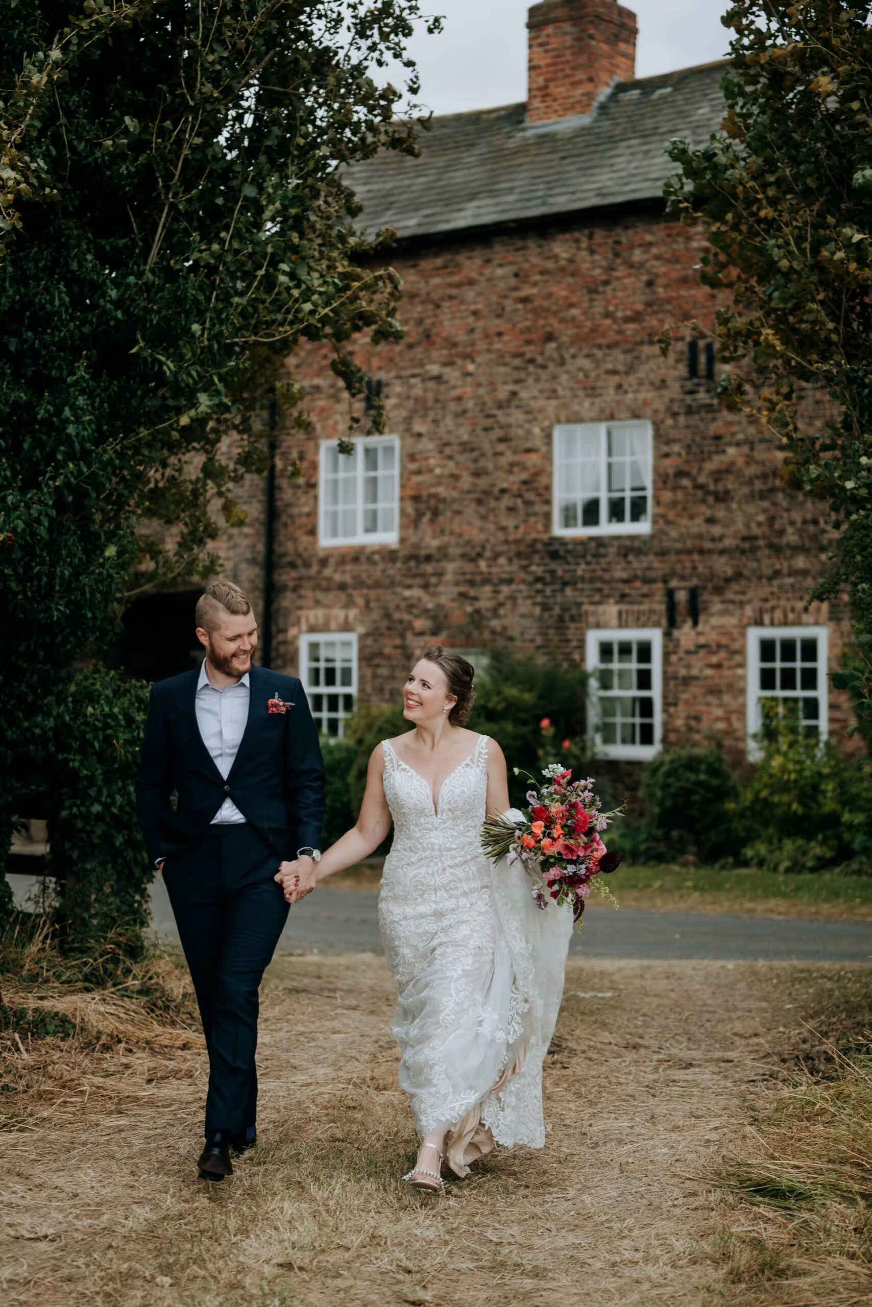 Bride and groom walking outside The Normans wedding venue