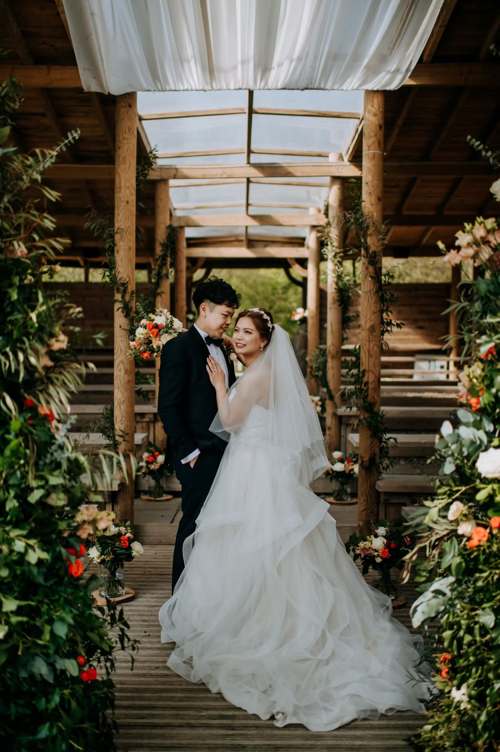 Bride and groom portrait under wooden walkway at Oaklands wedding venue