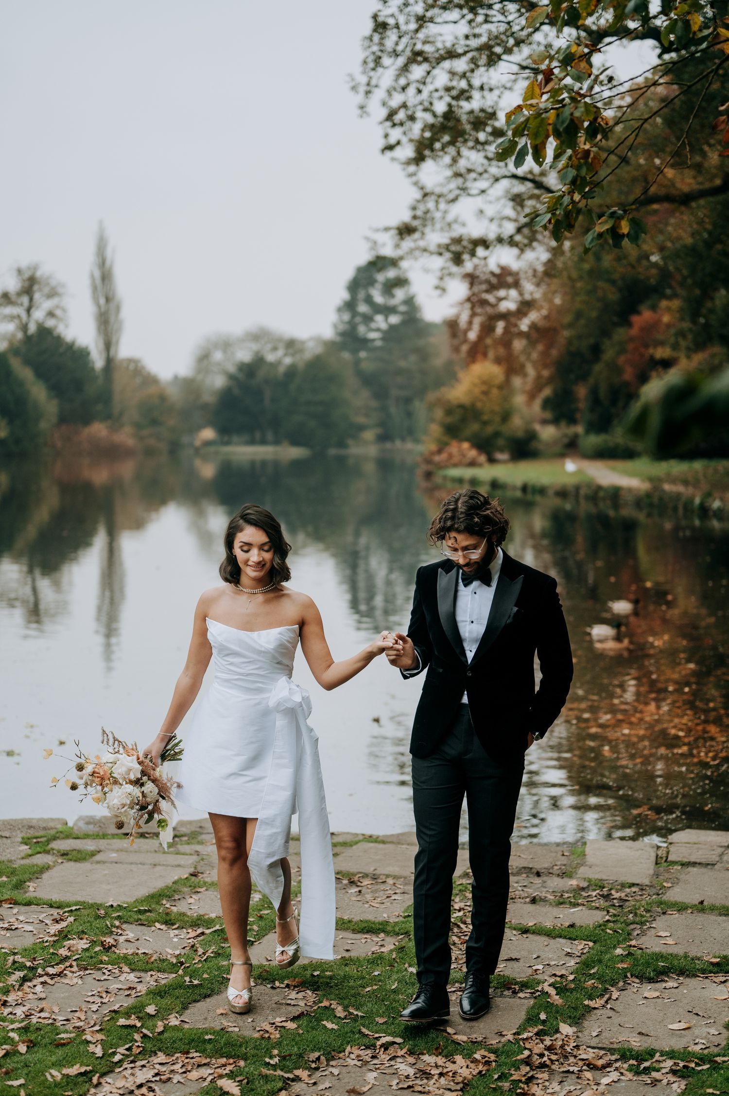 Bride and groom walking beside lake in Lincolnshire