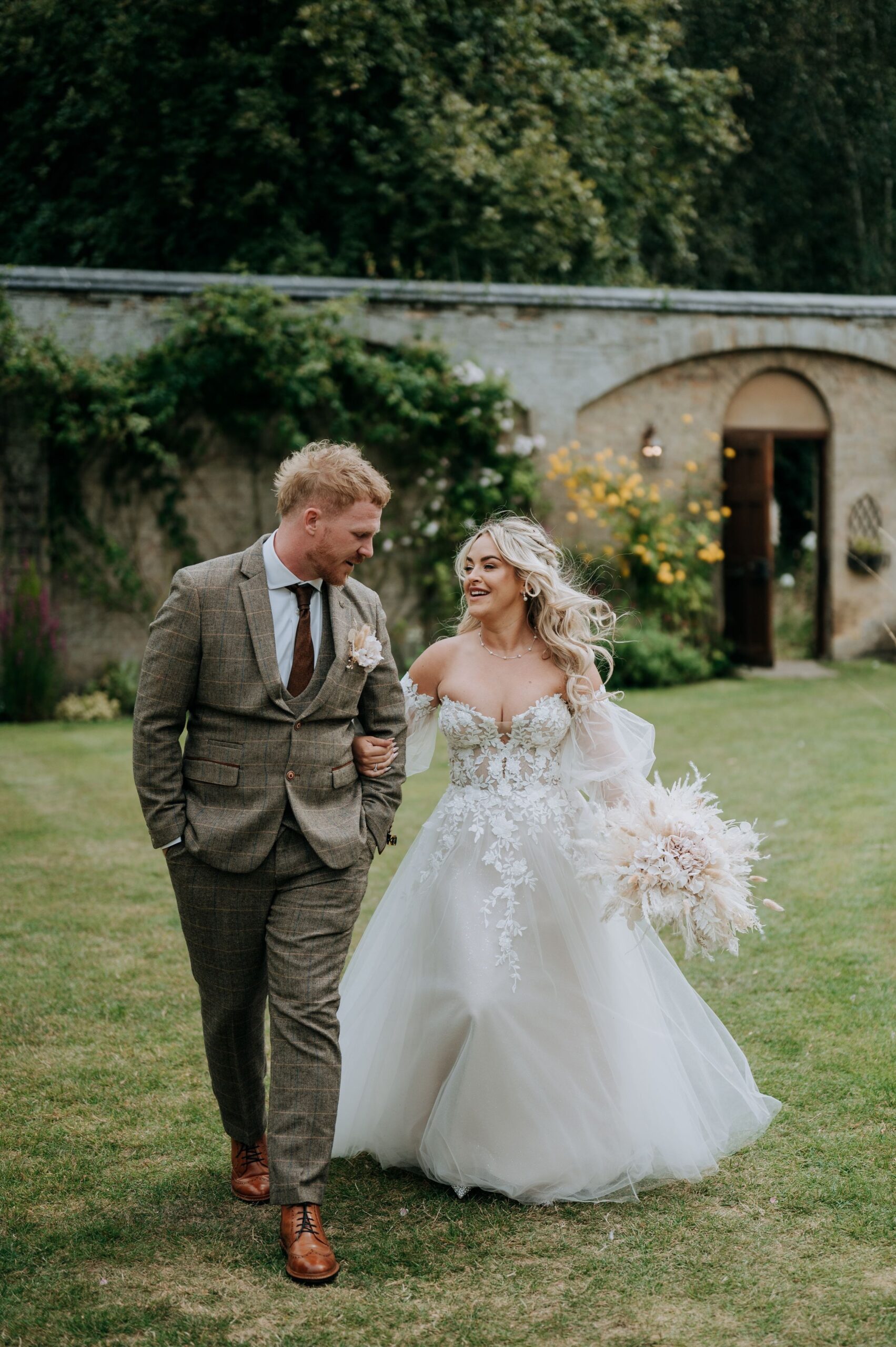 Bride and groom walking through Scrivelsby wedding venue gardens