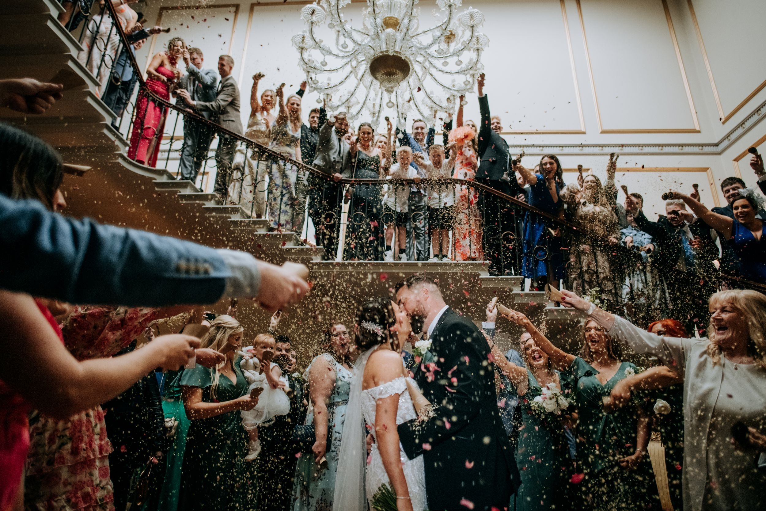 Wedding guests celebrating with confetti inside Rise Hall