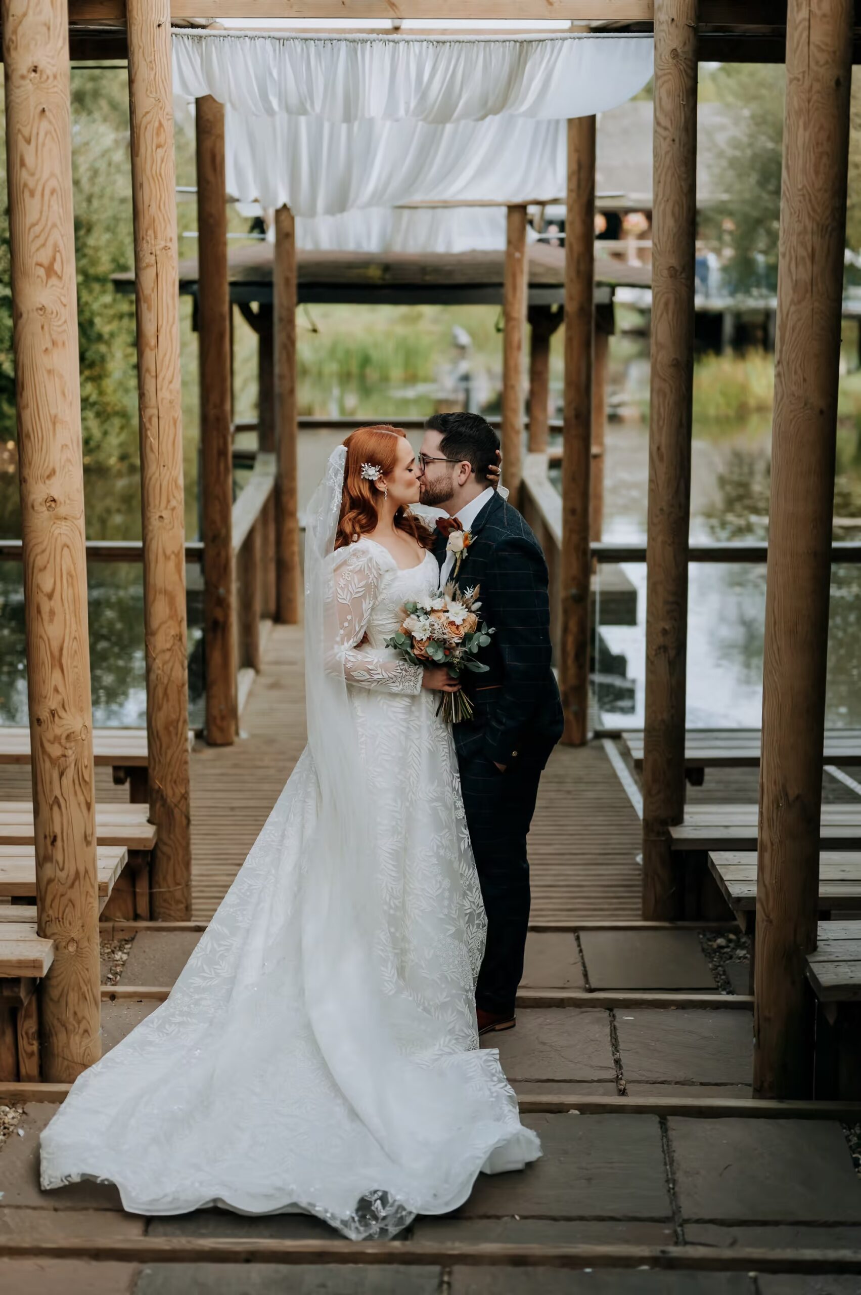 Bride and groom portrait beneath Oaklands wedding venue walkway