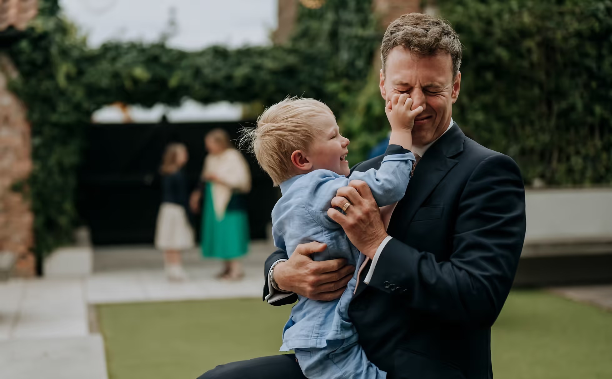 Father holding child during wedding day at The Normans
