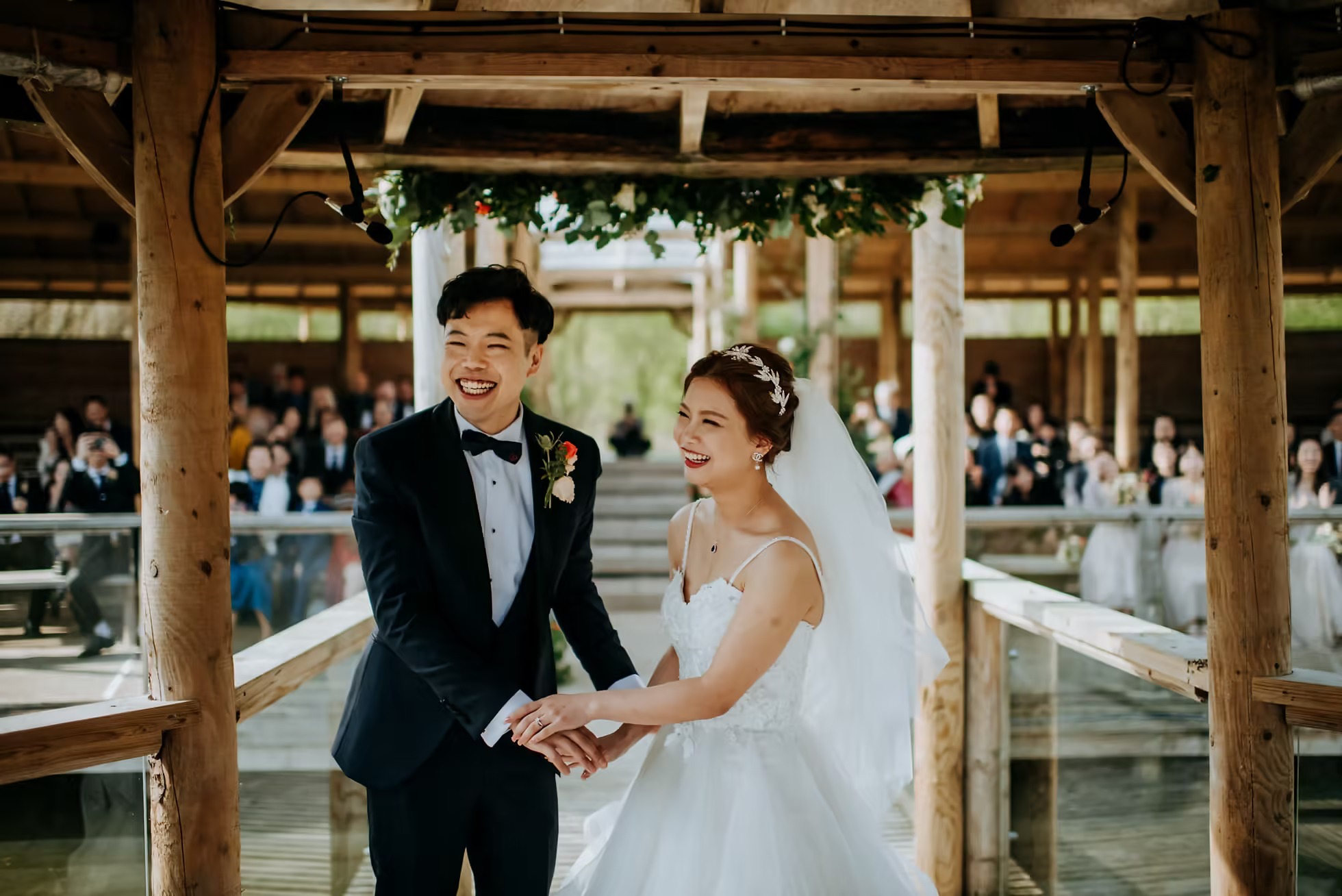 Bride and groom walking through Oaklands wedding venue walkway