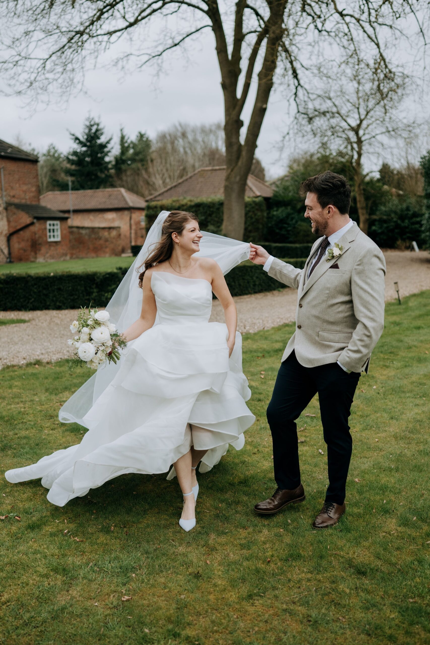 Bride and groom walking through gardens at Wootton Hall wedding venue