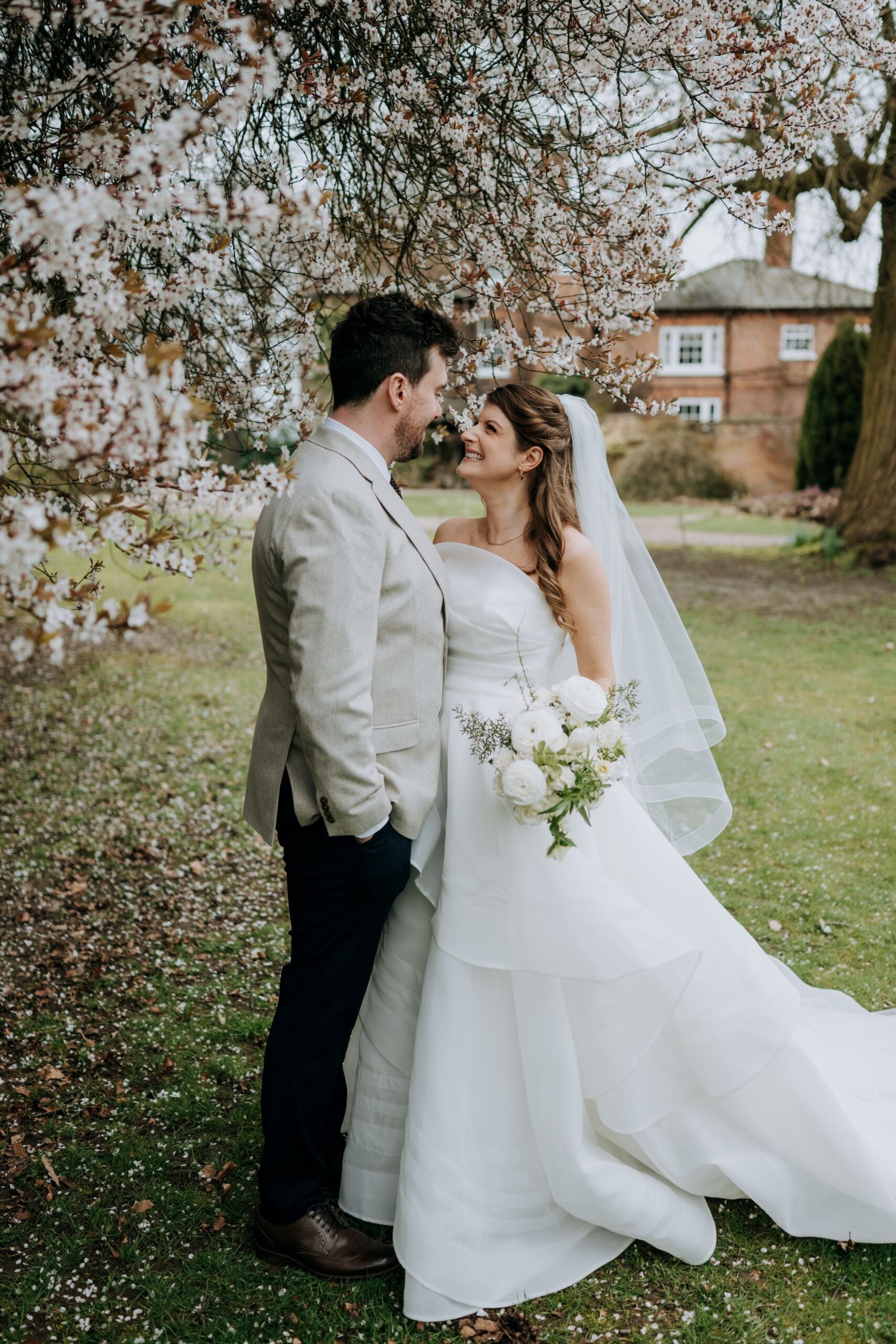 Bride and groom portrait beneath blossom tree at Wootton Hall