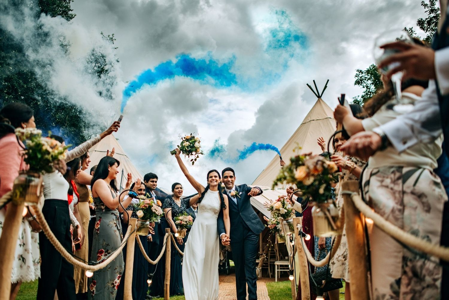 Wedding guests celebrating with blue smoke bombs in Lincolnshire