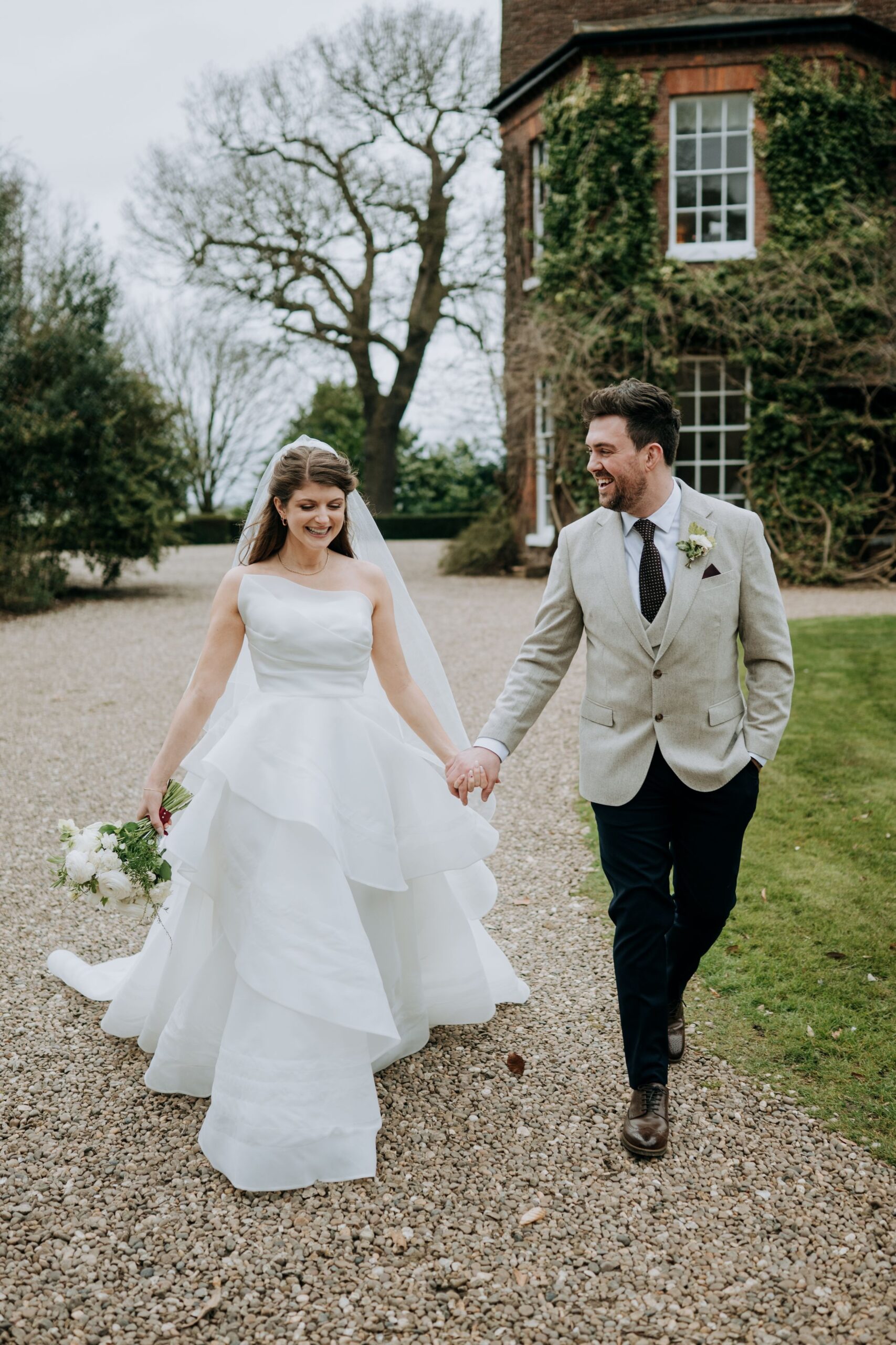 Bride and groom walking through gardens at Wootton Hall