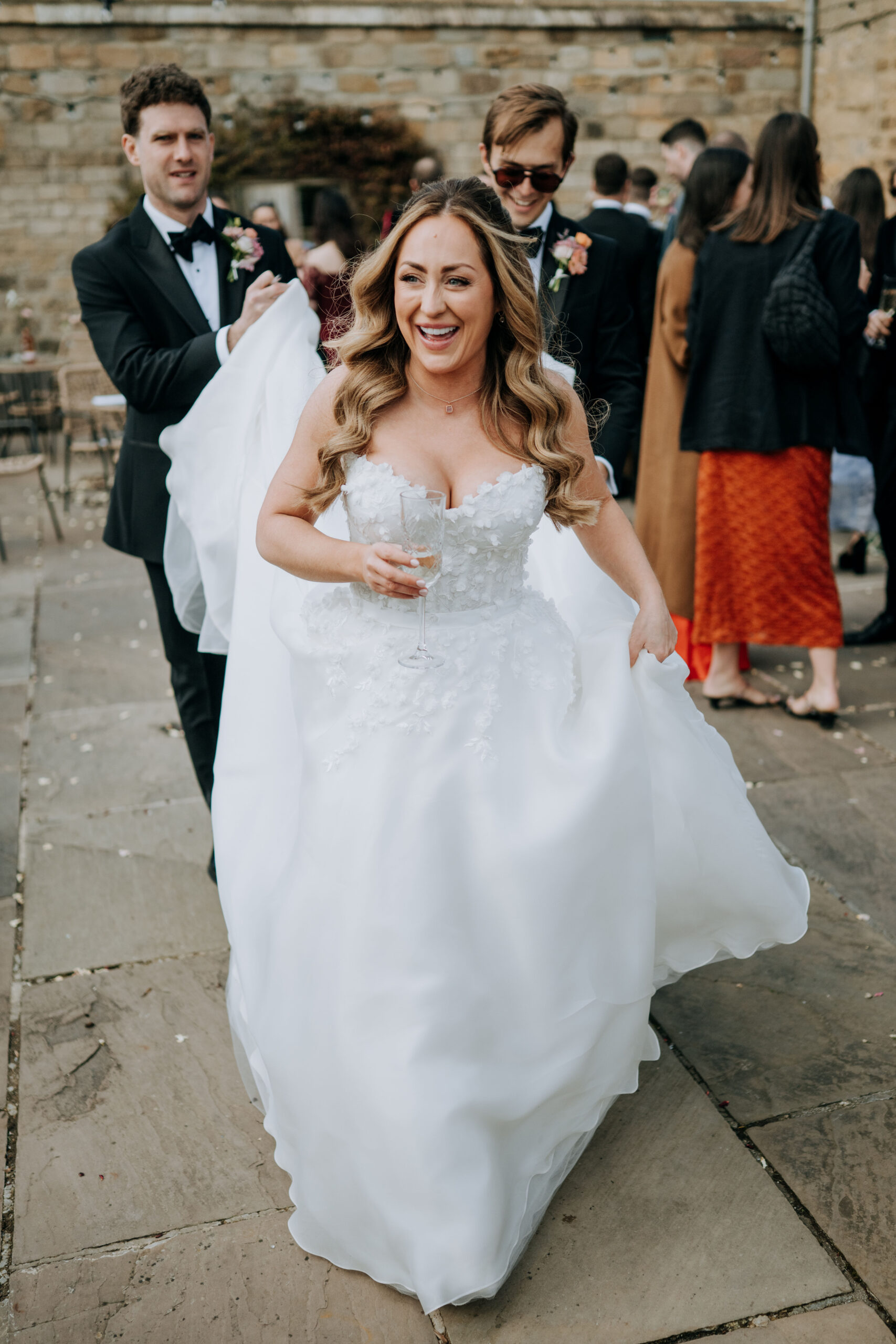 Bride and Groom carrying the back of the wedding dress at a Wharfdale Grange wedding.