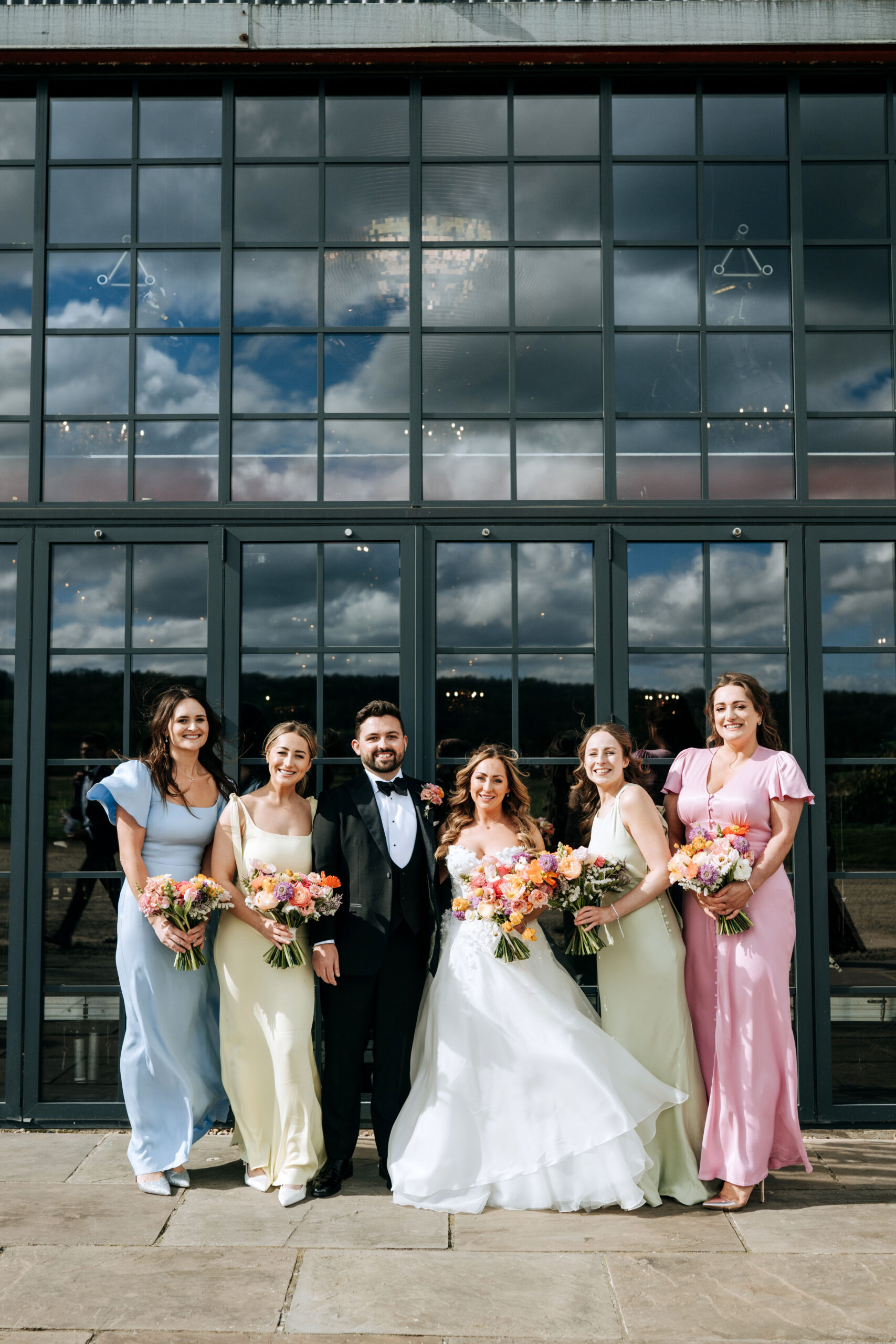 Bride and groom with bridesmaids celebrating outside Wharfedale Grange