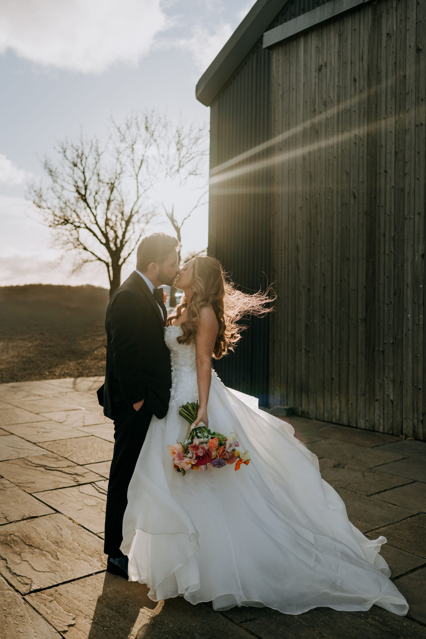 Bride and groom beside the barn at Wharfedale Grange